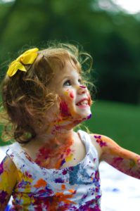 A little girl with paint all over her body enjoying unscheduled time with her family in Katy, TX 77494