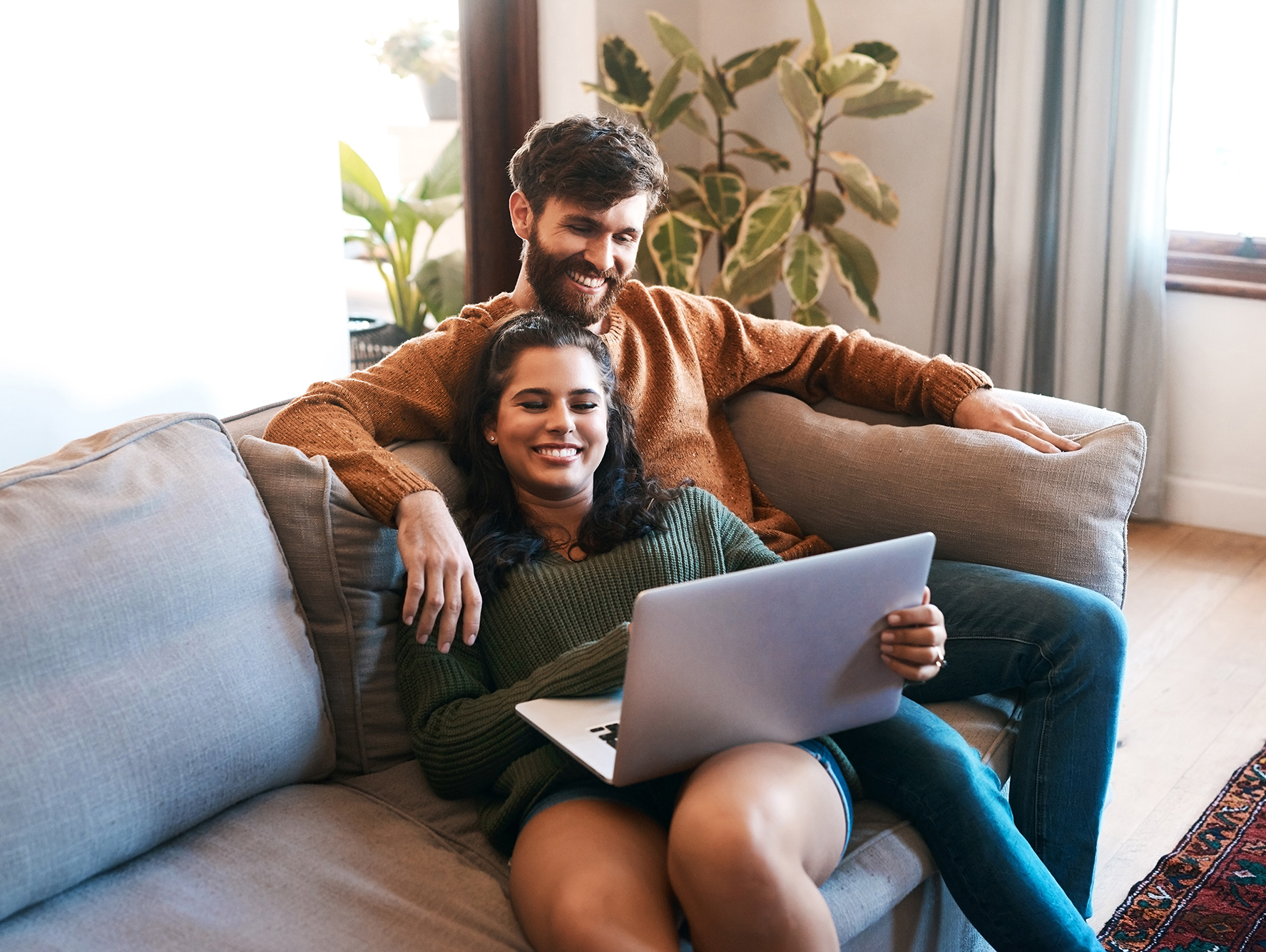 Young couple using a laptop while relaxing on the sofa at home. psychotherapist marriage counseling in katy, tx is the way to go for relationship help. katy couples counseling has the best therapist in Texas