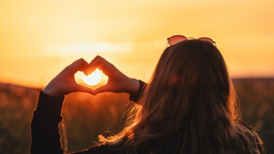 girl holding her hands in the sunset in the shape of a heart, Tips for Effective Self-Care as a Caregiver blog, mental health, locke counseling and consulting, katy texas 77494