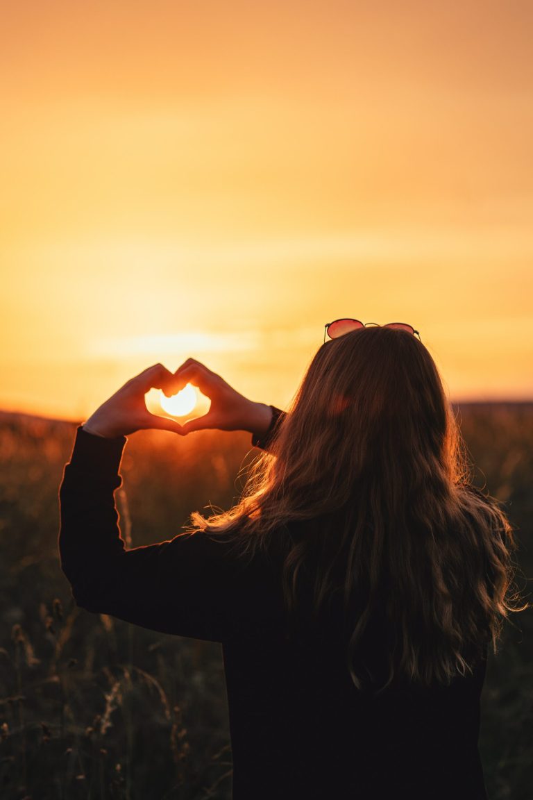 girl holding her hands in the sunset in the shape of a heart, Tips for Effective Self-Care as a Caregiver blog, mental health, locke counseling and consulting, katy texas 77494